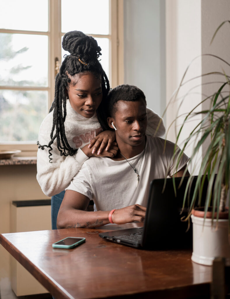 Black couple on computer having a virtual couples therapy session with a marriage counselor